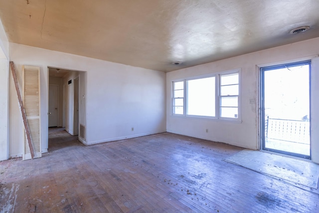 empty room with visible vents and hardwood / wood-style flooring