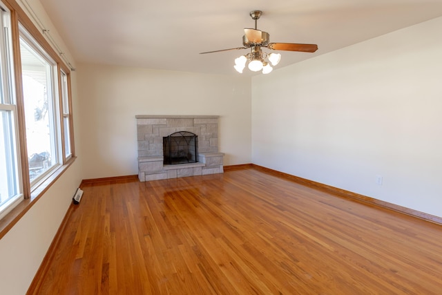 unfurnished living room featuring light wood-style flooring, a fireplace, baseboards, and ceiling fan