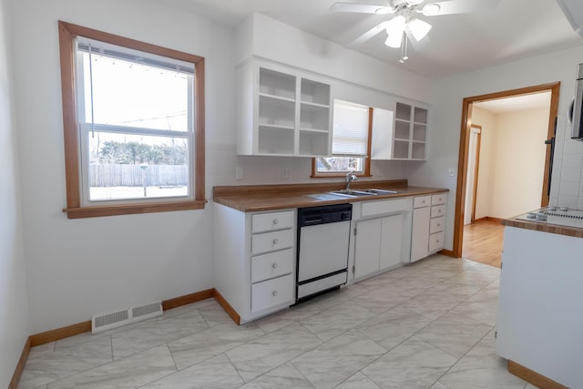 kitchen featuring visible vents, open shelves, dishwasher, white cabinets, and a sink