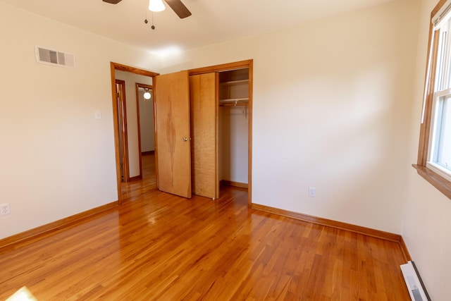 unfurnished bedroom with light wood-style floors, visible vents, a closet, and baseboards