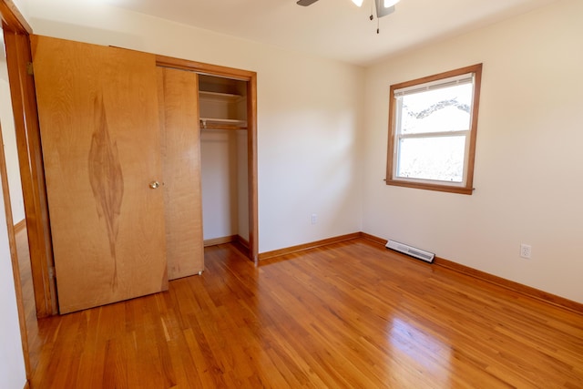 unfurnished bedroom featuring a ceiling fan, baseboards, visible vents, light wood finished floors, and a closet