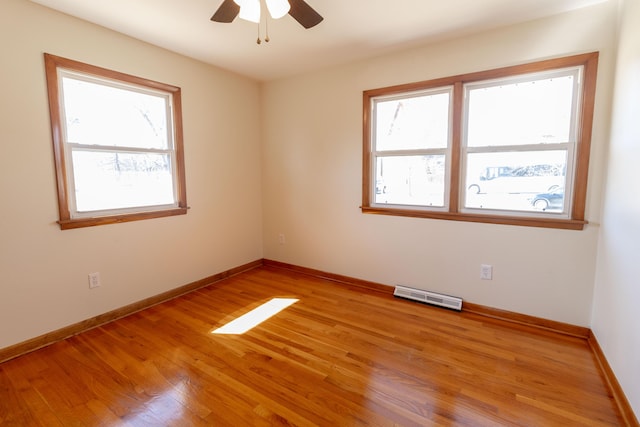 empty room featuring visible vents, baseboards, ceiling fan, and light wood finished floors