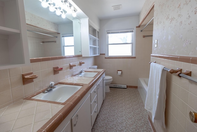 bathroom with a sink, plenty of natural light, and wallpapered walls