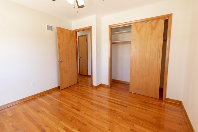 unfurnished bedroom with light wood finished floors, visible vents, a closet, and baseboards