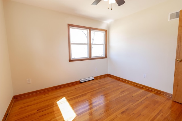 unfurnished room featuring light wood finished floors, visible vents, and baseboards