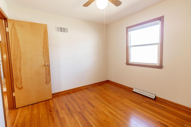 empty room featuring visible vents, a ceiling fan, light wood-type flooring, and baseboards