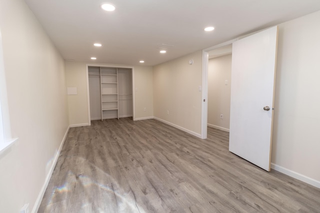 basement with recessed lighting, wood finished floors, and baseboards