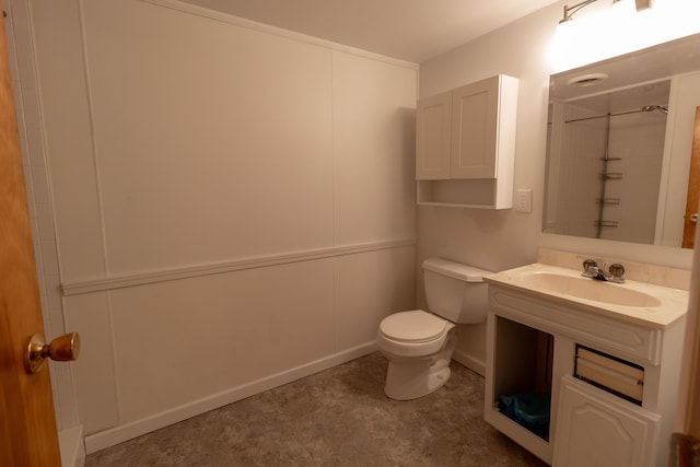 bathroom featuring walk in shower, toilet, and a sink