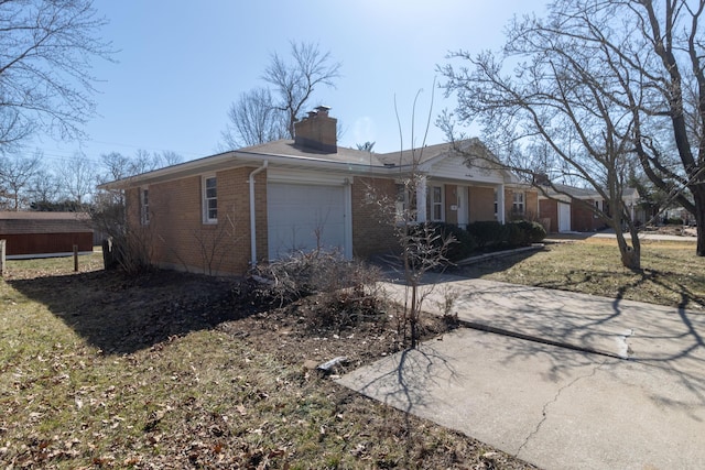 view of front of house with driveway, brick siding, a chimney, and an attached garage