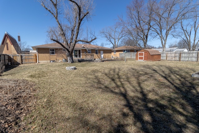 exterior space with an outbuilding, a storage unit, a fenced backyard, and a wooden deck