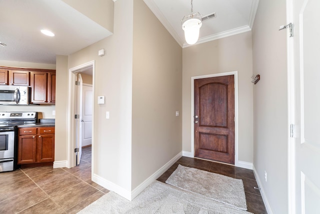 tiled foyer entrance featuring visible vents, baseboards, and ornamental molding