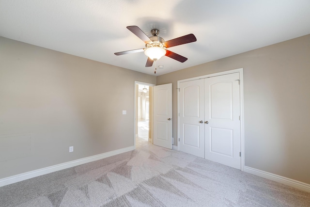 unfurnished bedroom with a ceiling fan, baseboards, a closet, and light carpet