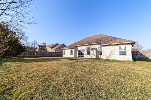 back of property featuring a yard and a fenced backyard