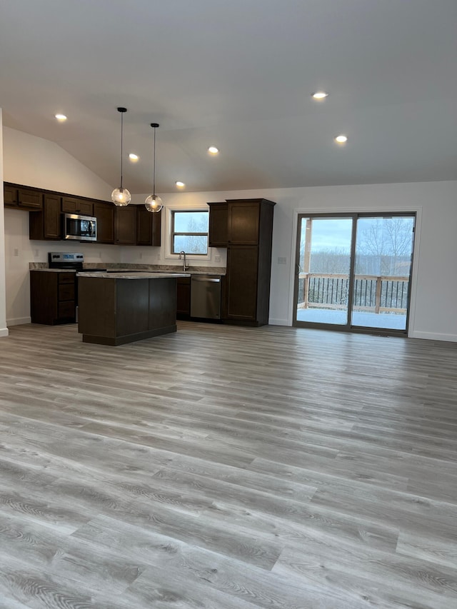 kitchen featuring appliances with stainless steel finishes, lofted ceiling, open floor plan, and dark brown cabinets