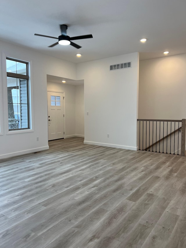 empty room with baseboards, visible vents, wood finished floors, and recessed lighting