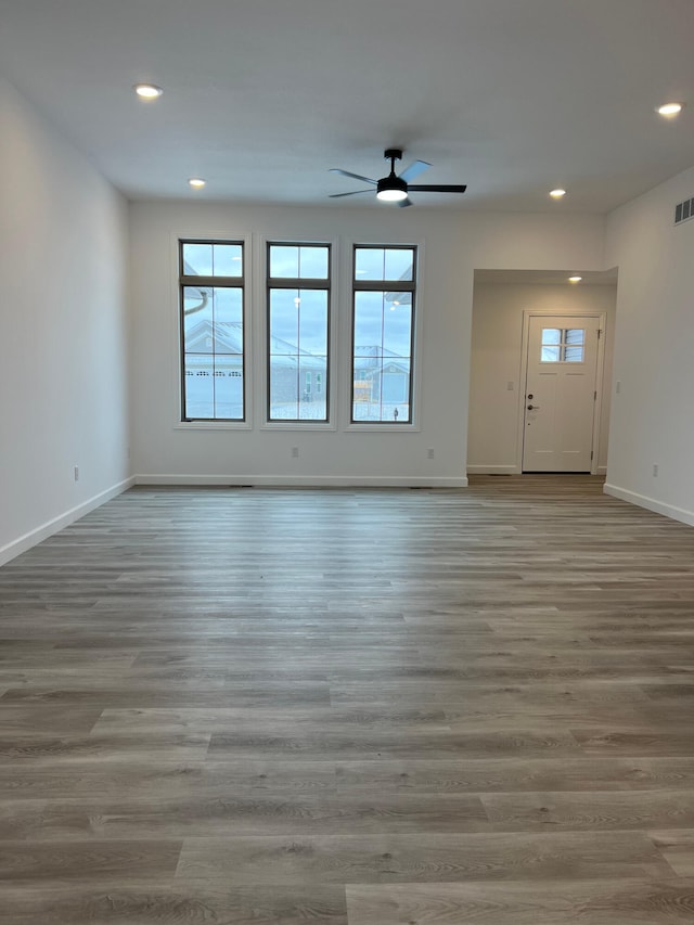 unfurnished living room featuring recessed lighting, wood finished floors, visible vents, and baseboards