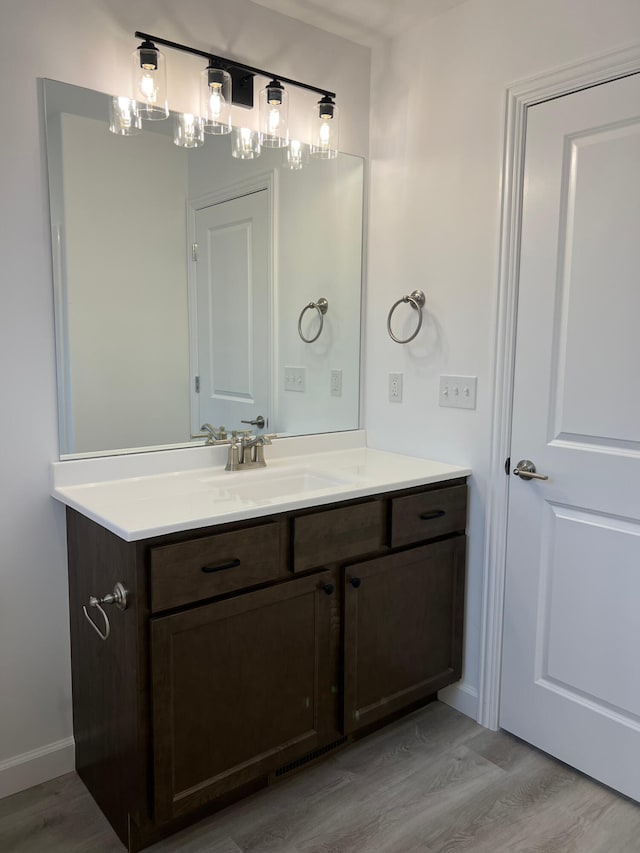 bathroom featuring wood finished floors, vanity, and baseboards