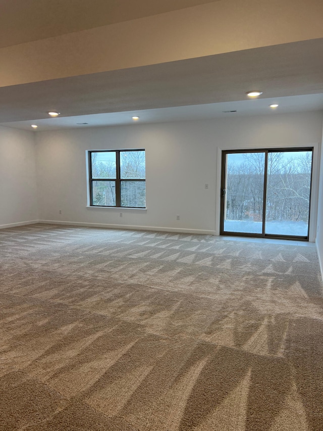 carpeted spare room with recessed lighting, a wealth of natural light, and baseboards