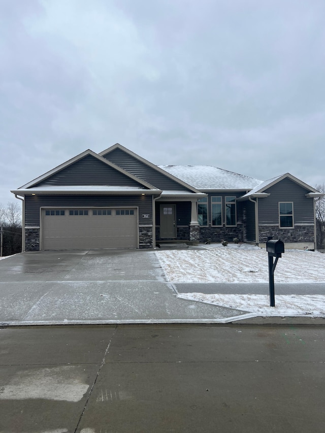 view of front of property with a garage, stone siding, and driveway