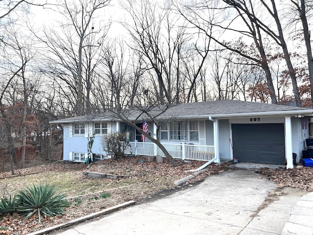 ranch-style home featuring a porch, a garage, brick siding, a shingled roof, and concrete driveway