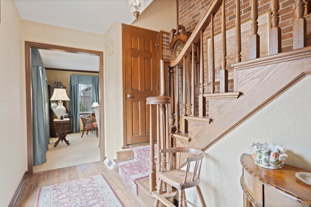 stairway with visible vents, wood finished floors, and baseboards