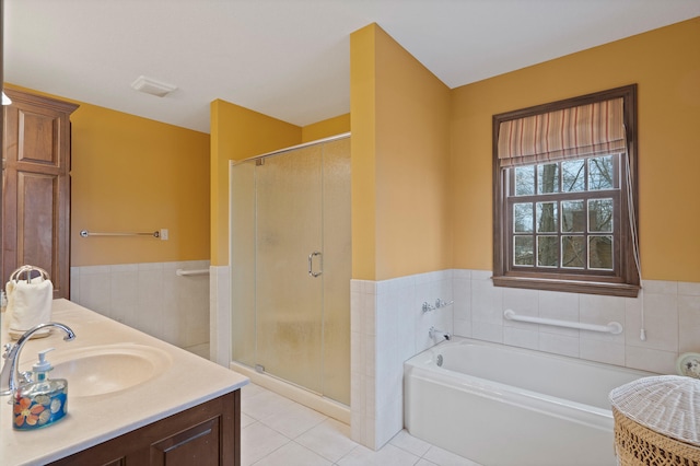 bathroom featuring tile patterned flooring, a shower stall, a bath, and a wainscoted wall