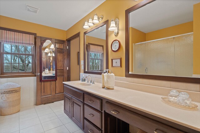 full bath with vanity, a shower stall, and tile patterned flooring