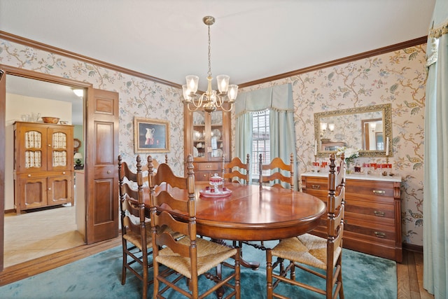 dining space with wallpapered walls, crown molding, and wood finished floors