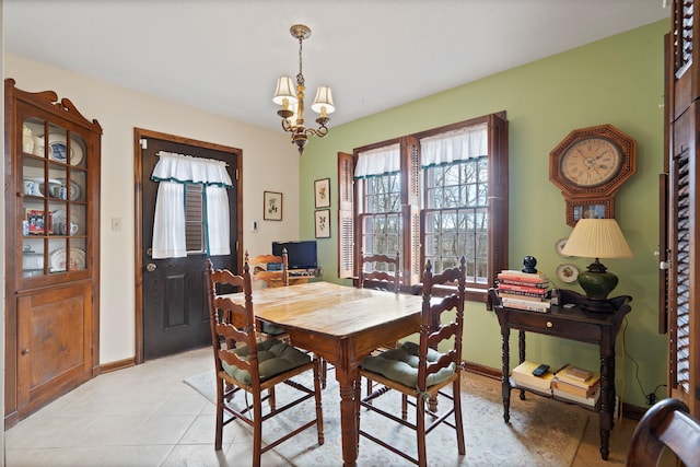 dining area featuring light tile patterned floors, baseboards, and a chandelier