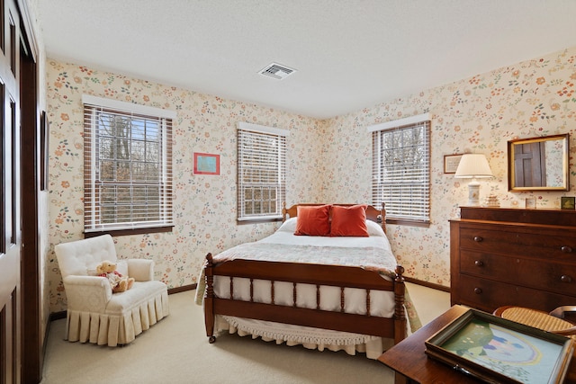 carpeted bedroom with visible vents, baseboards, and wallpapered walls