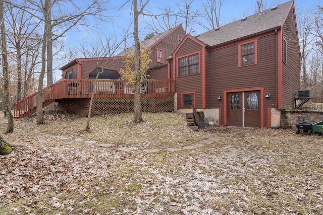 rear view of property featuring a shingled roof, stairs, and a deck