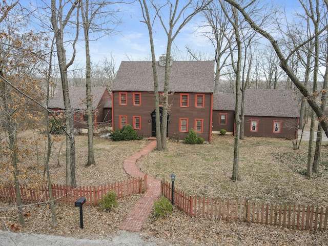 colonial house with fence and a shingled roof