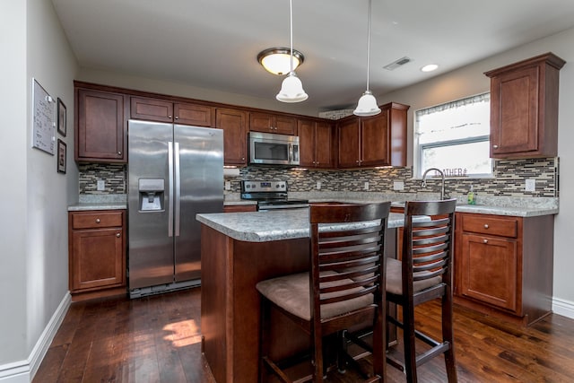 kitchen with stainless steel appliances, visible vents, dark wood-style flooring, and light countertops