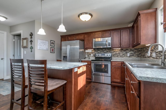 kitchen featuring dark wood-style flooring, a sink, stainless steel appliances, light countertops, and backsplash