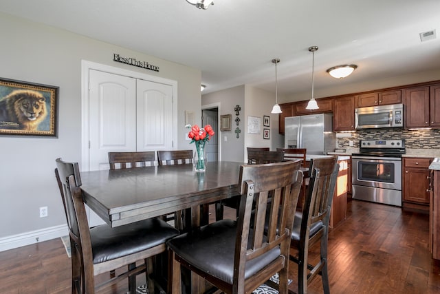 dining area featuring dark wood-style floors, visible vents, and baseboards