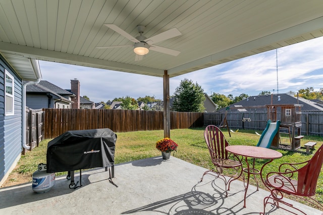 view of patio / terrace featuring area for grilling, a fenced backyard, a ceiling fan, and a playground