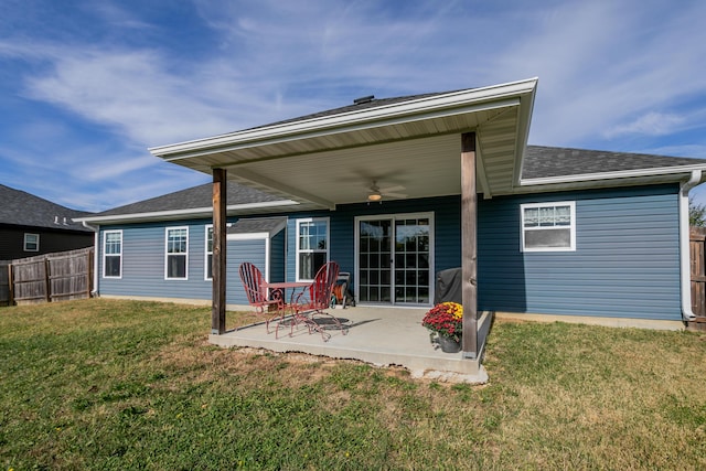 rear view of property featuring a lawn, a patio, fence, a shingled roof, and ceiling fan