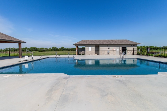 community pool with a patio and fence