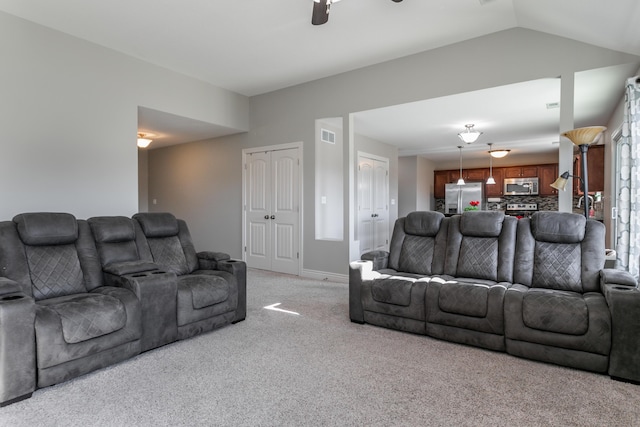 living area featuring a ceiling fan, visible vents, baseboards, vaulted ceiling, and light colored carpet