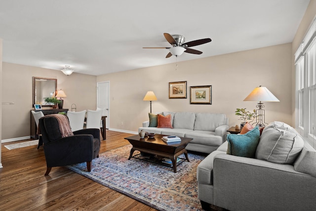 living area with ceiling fan, baseboards, and wood finished floors