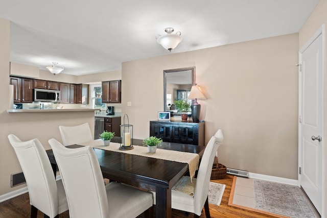 dining room with baseboards and wood finished floors