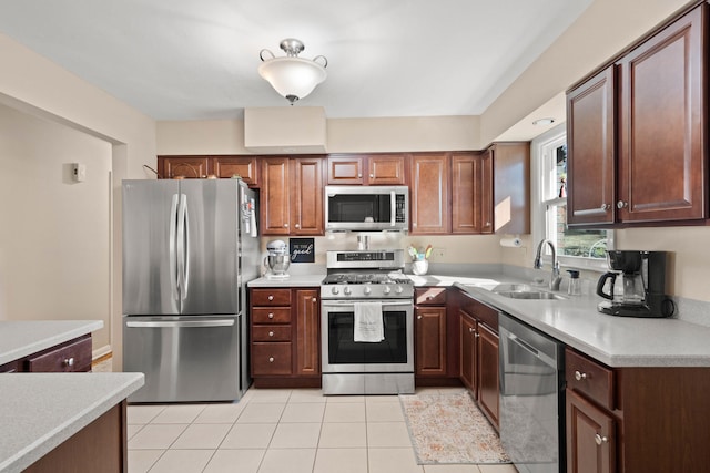 kitchen with stainless steel appliances, light countertops, a sink, and light tile patterned flooring