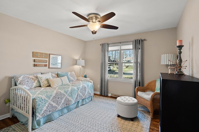 bedroom featuring a ceiling fan, baseboards, and wood finished floors