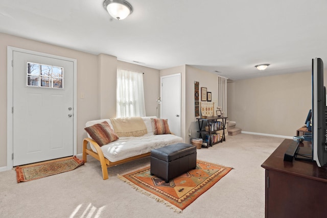 carpeted living area featuring baseboards and stairs