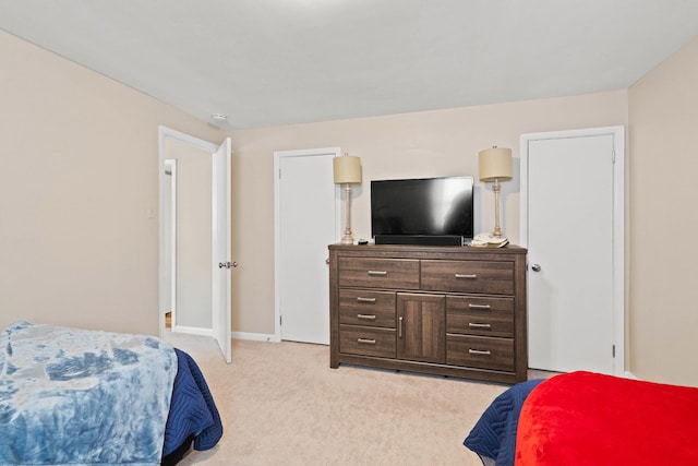 bedroom with baseboards and light colored carpet