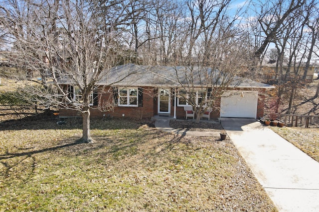 single story home featuring a garage, driveway, a front yard, and brick siding