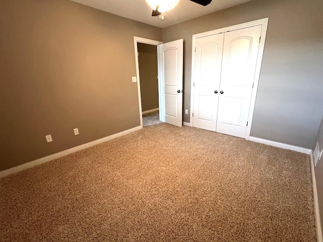 unfurnished bedroom with carpet floors, a closet, baseboards, and a ceiling fan