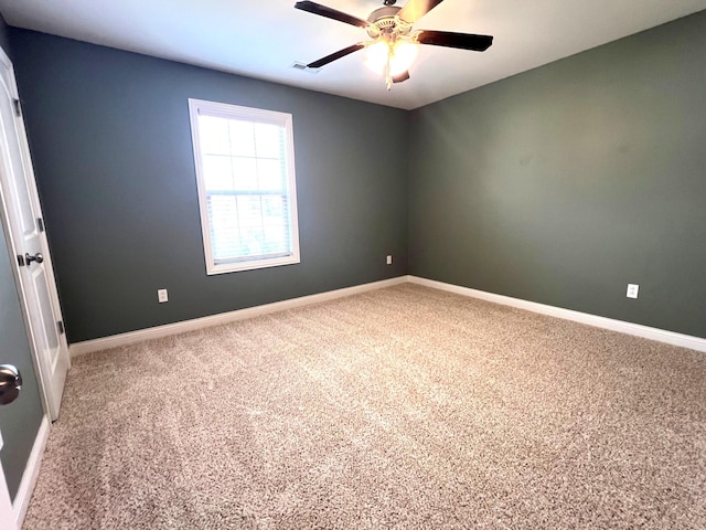 spare room featuring carpet and baseboards