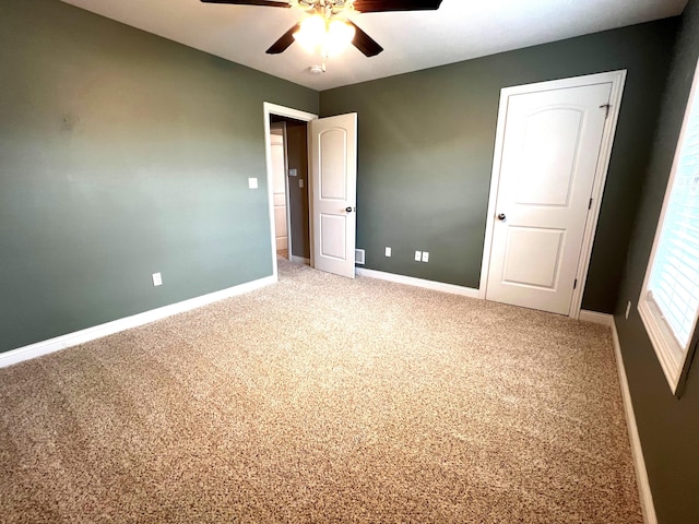 unfurnished bedroom featuring ceiling fan, baseboards, and light colored carpet