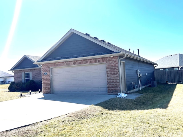 view of home's exterior featuring driveway, a garage, a lawn, fence, and brick siding